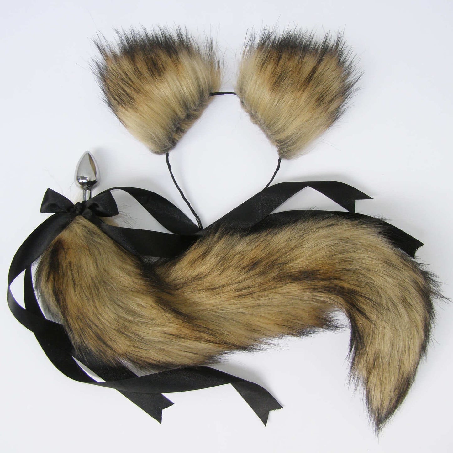 A brown faux fur cat tail butt plug with a stainless steel plug and a black ribbon attached.