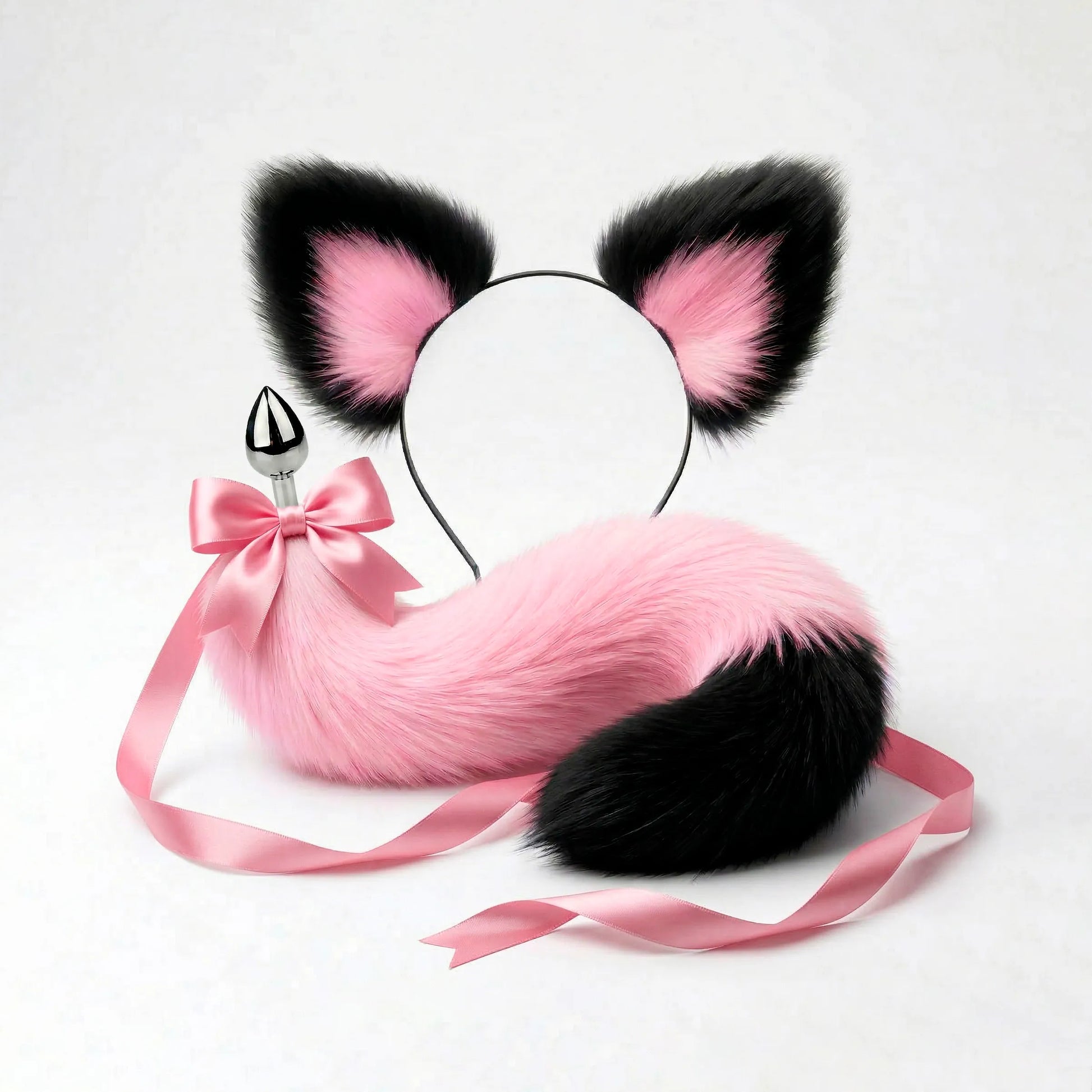 Furry faux fur pink and black cat tail butt plug and ears with a bow on a white background