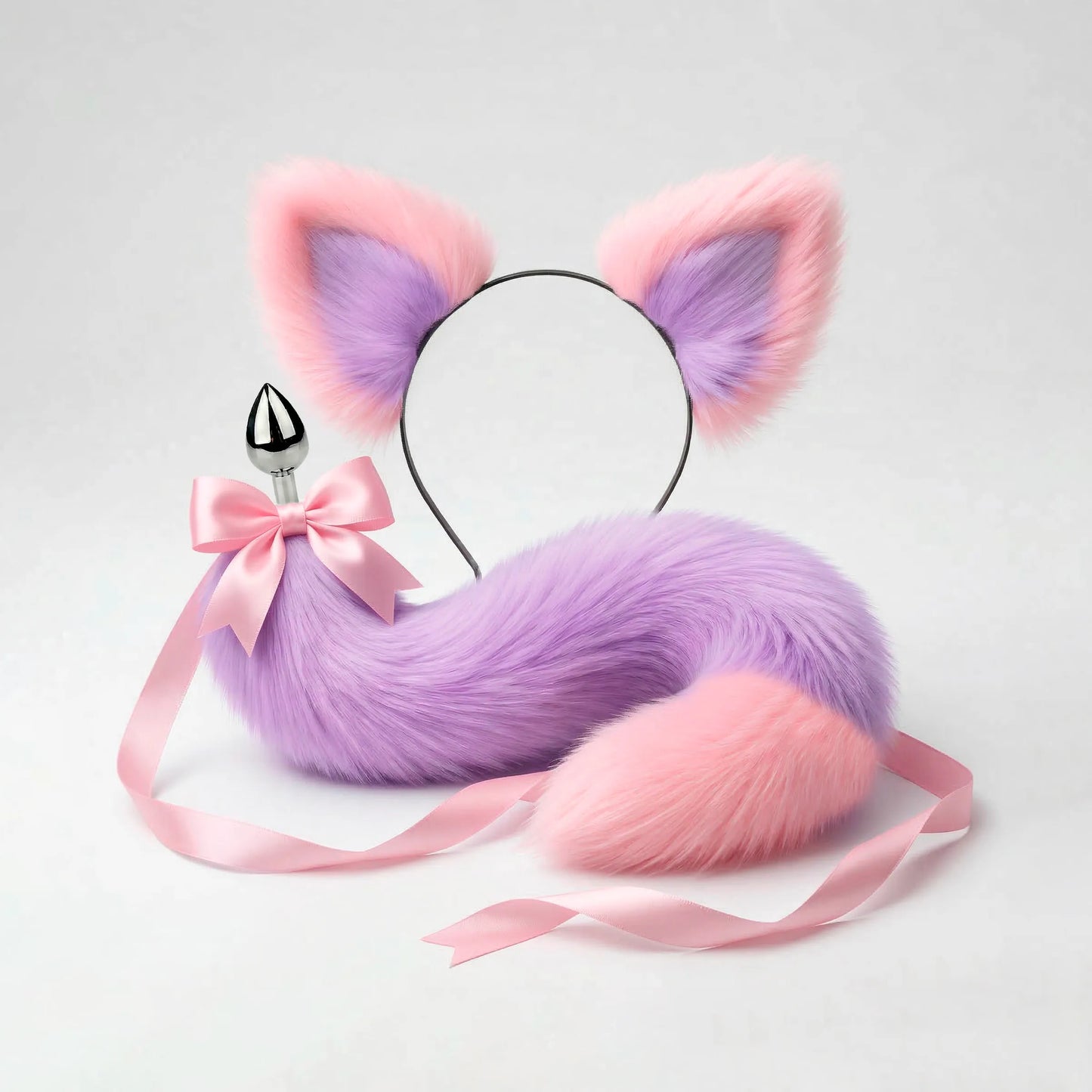 Furry faux fur purple and pink cat tail butt plug and ears with a bow on a white background